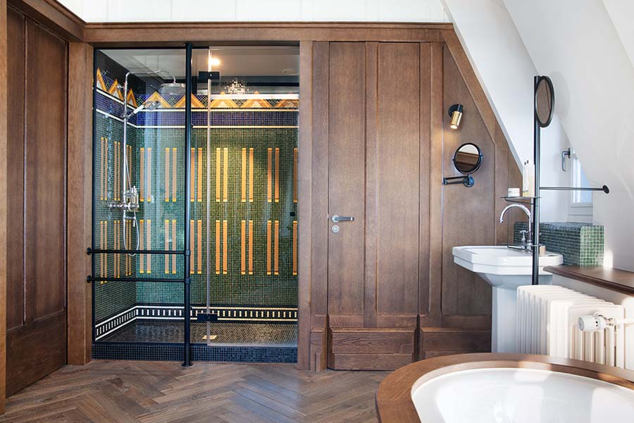 Salle de bain avec des mosaiques dans une chambre du Château Richeux