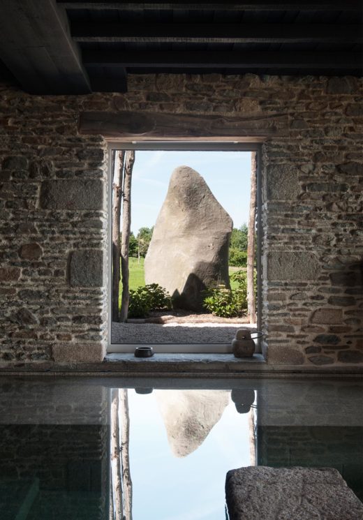 villa en pierre avec une vue extérieure sur une grande pierre de type ménir
