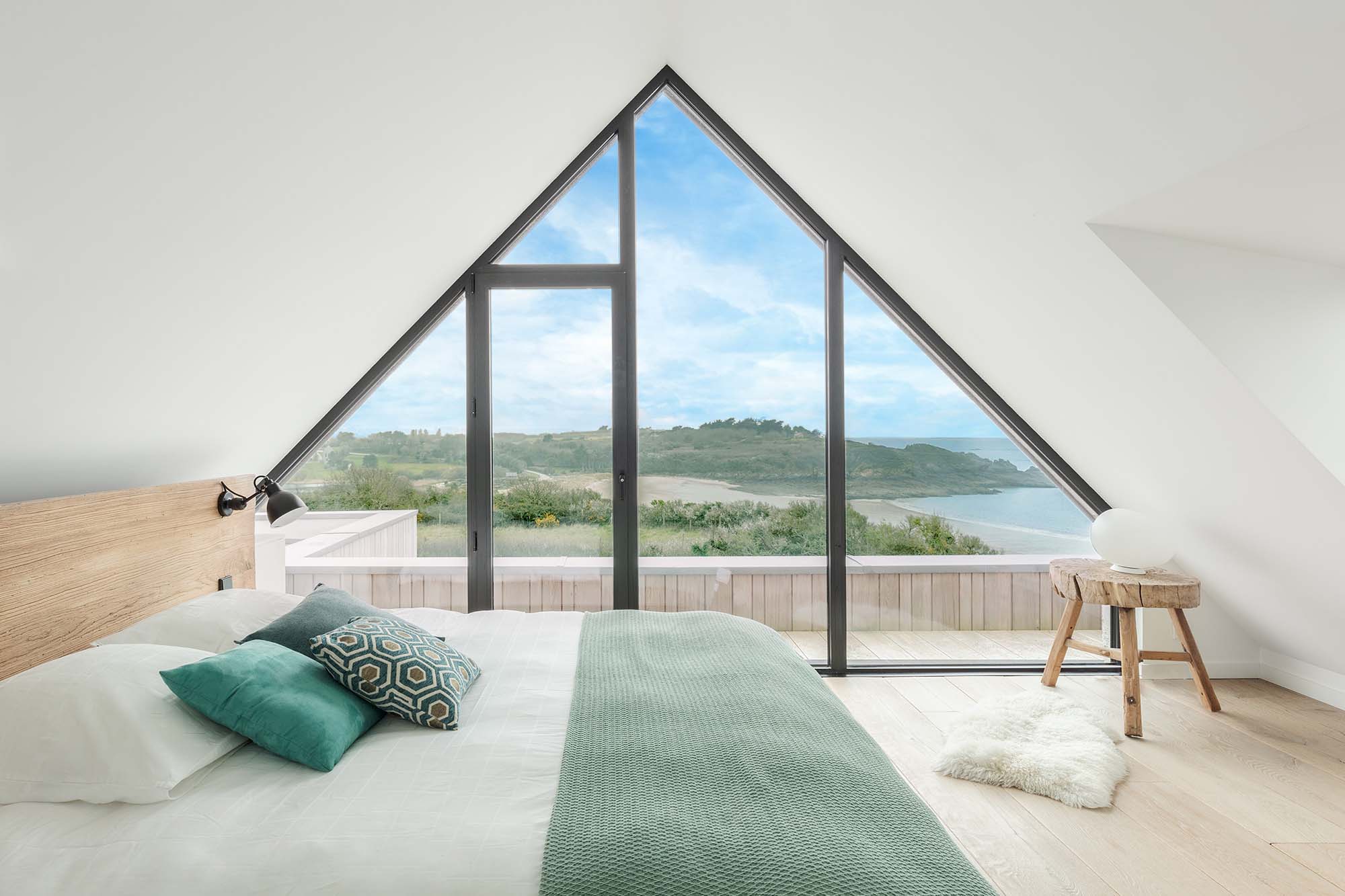 chambre avec une fenêtre triangulaire donnant sur la mer