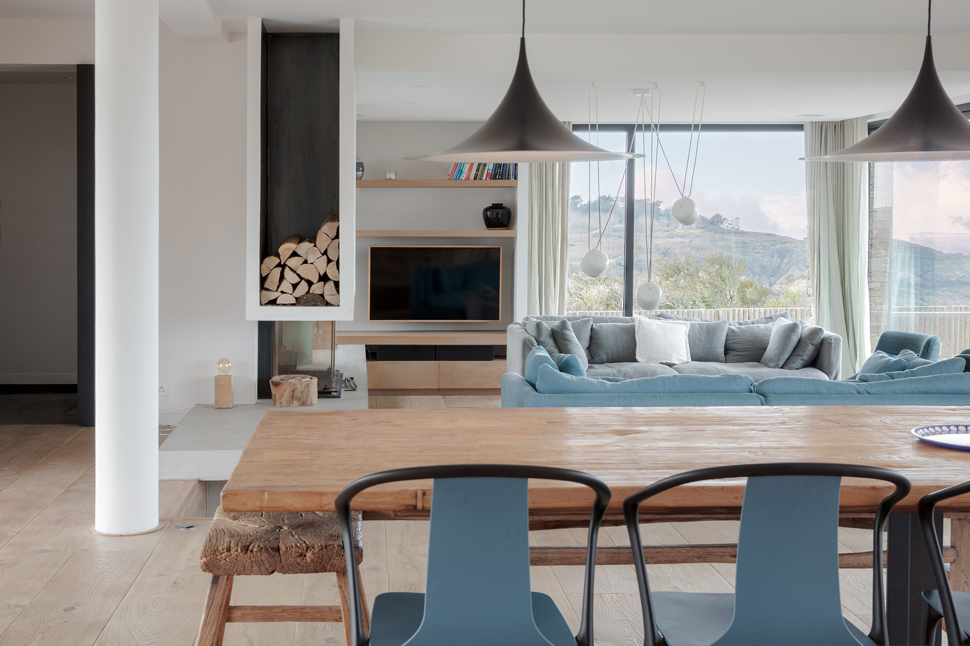 salle à manger ouverte sur le salon avec des baies vitrées donnant sur les montagnes