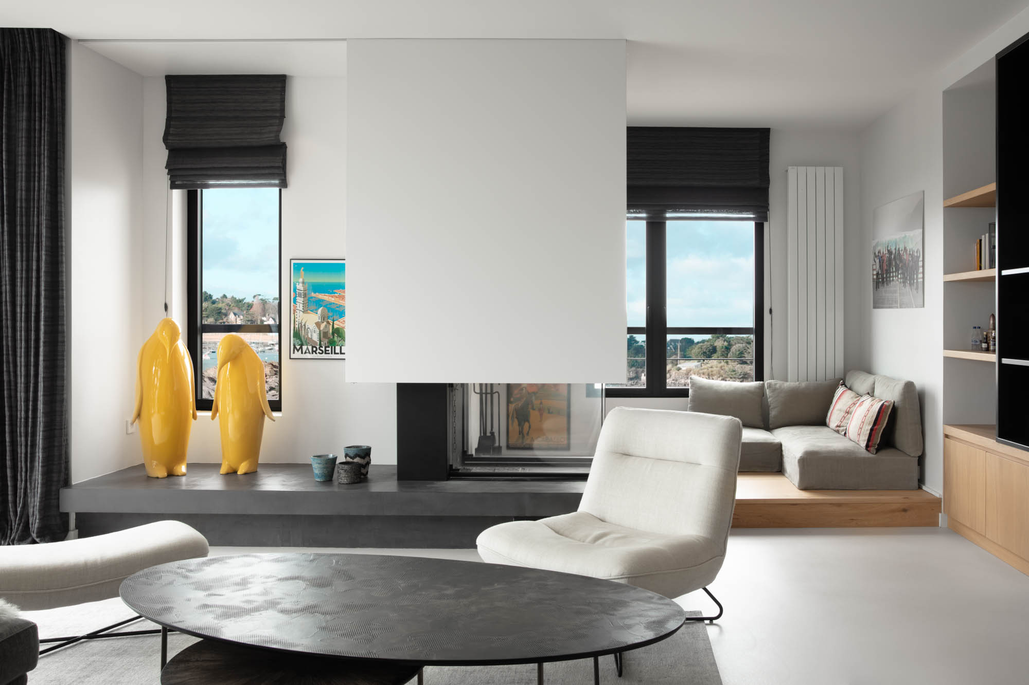 salon au design épuré avec une cheminée et une vue sur la mer