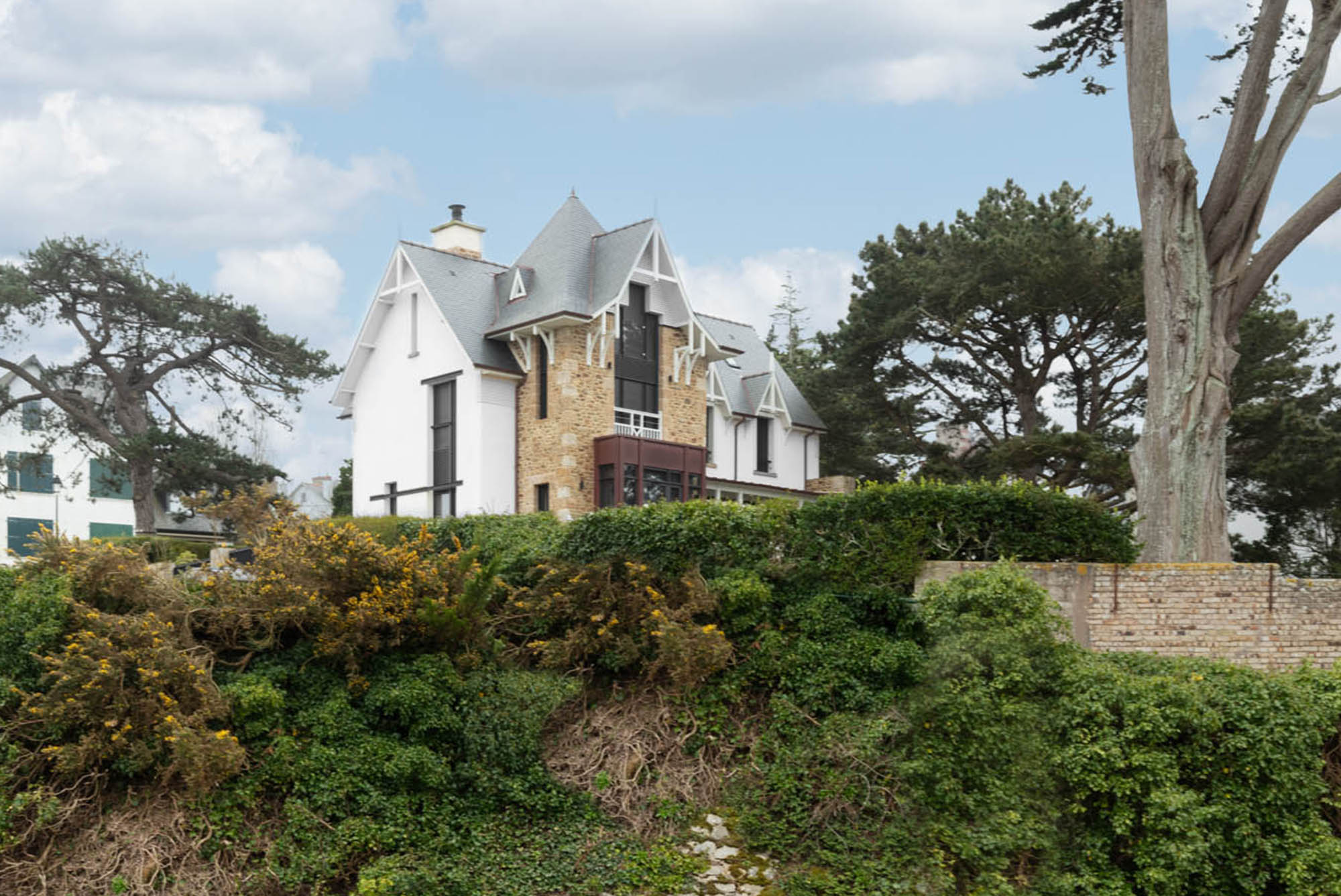 villa aux murs blancs et en pierres avec un jardin