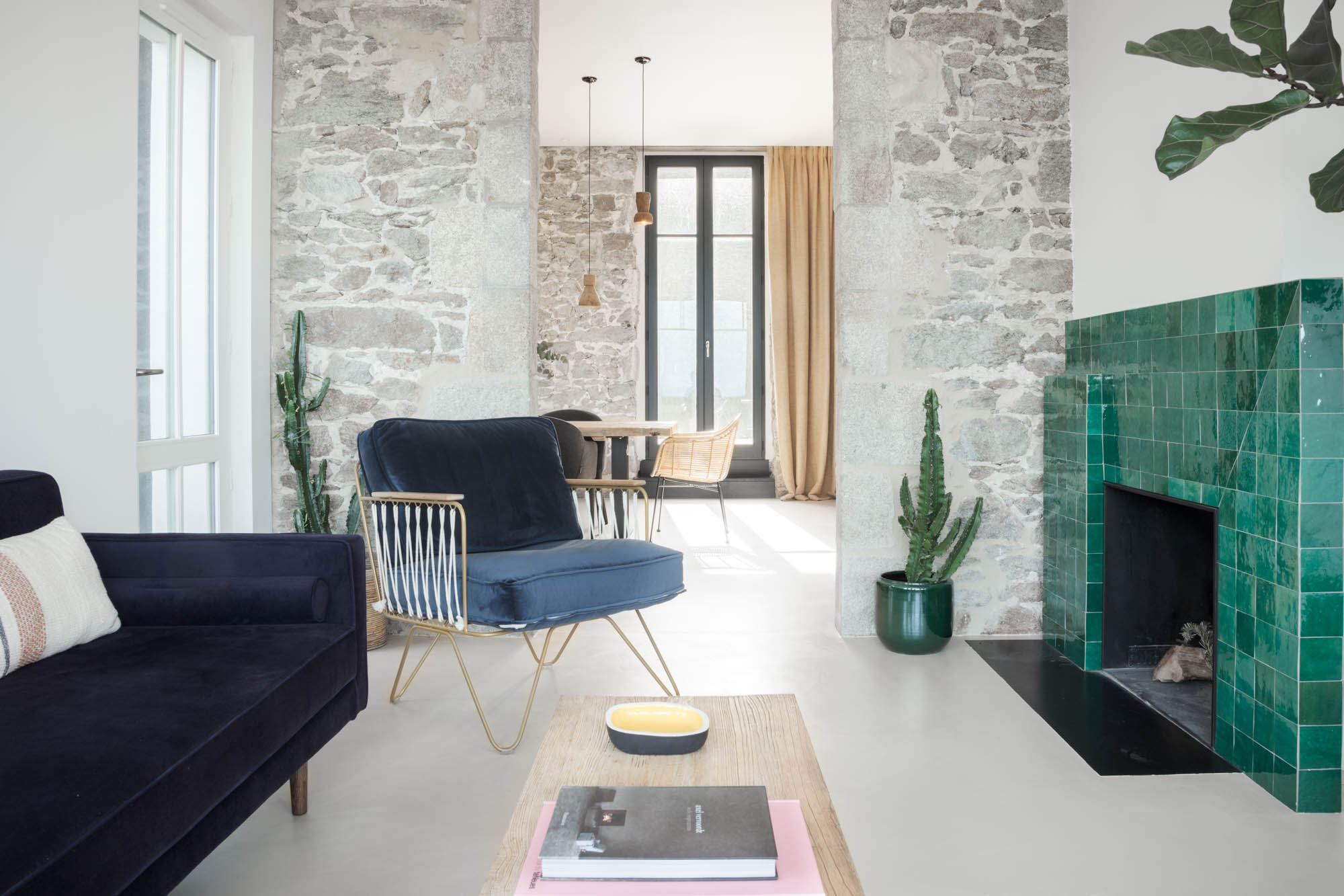 salon avec des fauteuils bleus et une cheminée en mosaïque verte