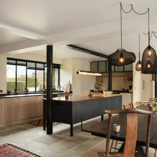 cuisine avec un ilot central en bois noir et une salle à manger en bois