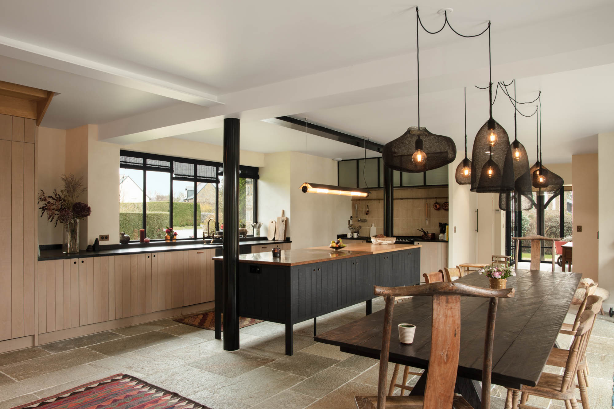 cuisine avec un ilot central en bois noir et une salle à manger en bois