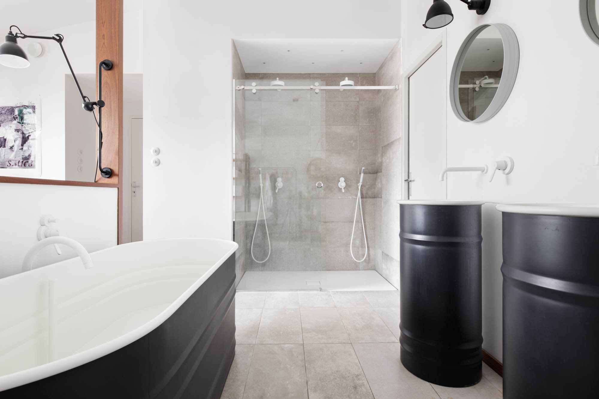 salle de bain avec une baignoire habillage noir et une douche à l'italienne vitrée