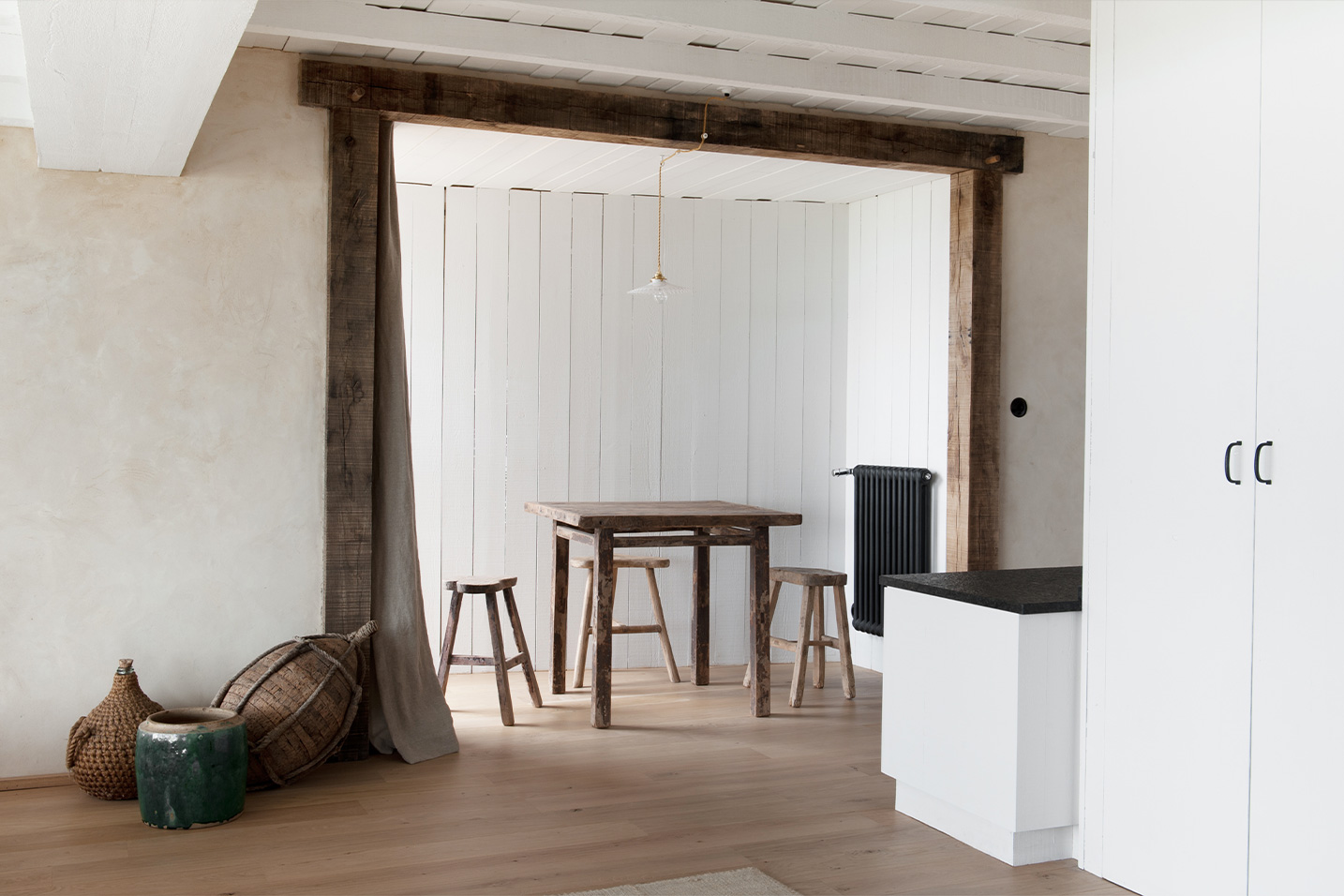 maison avec une table et des chaises hautes en bois et des murs en chaux
