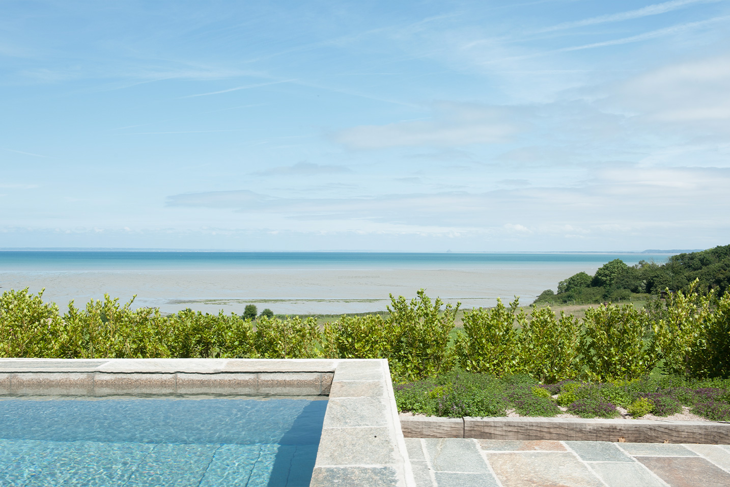 terrasse en pierre avec une piscine vue sur la mer