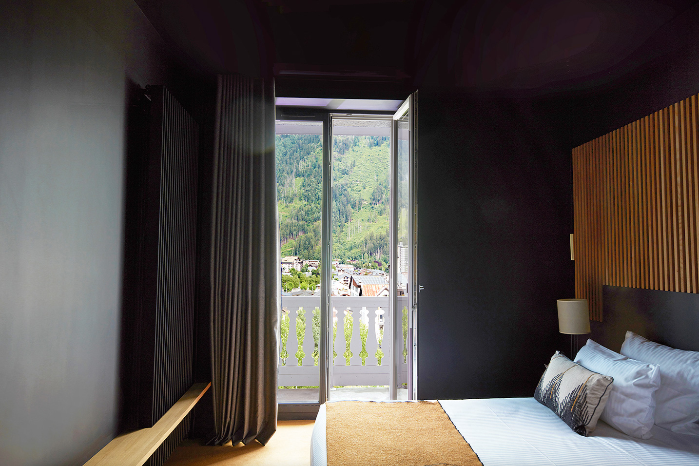 chambre d'hotel aux murs noirs avec vue sur les montagnes