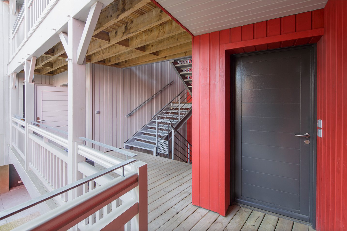 extérieur d'un collectif avec des ventelles en bois rouges