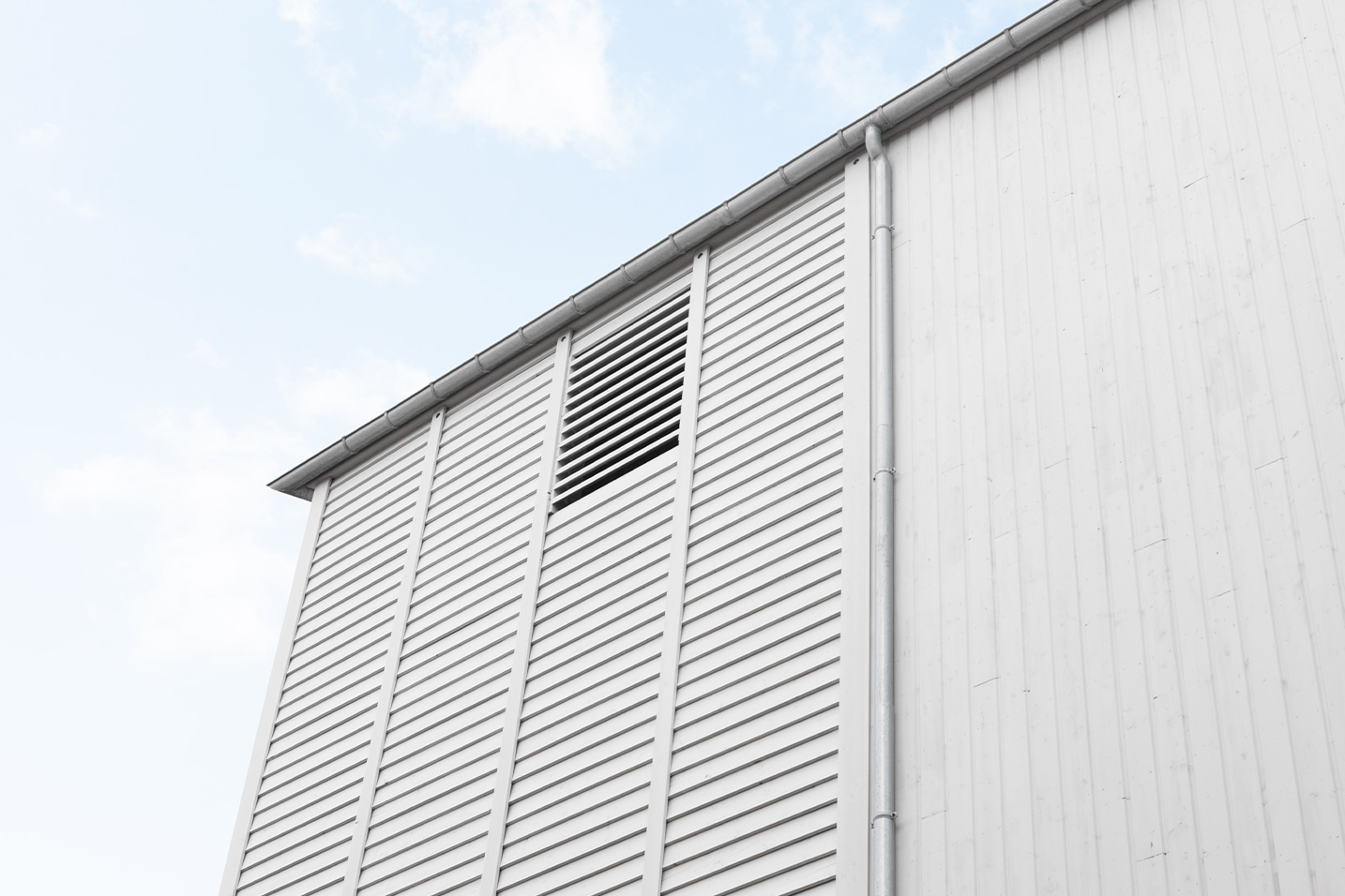 façade avec des ventelles horizontales et verticales en bois