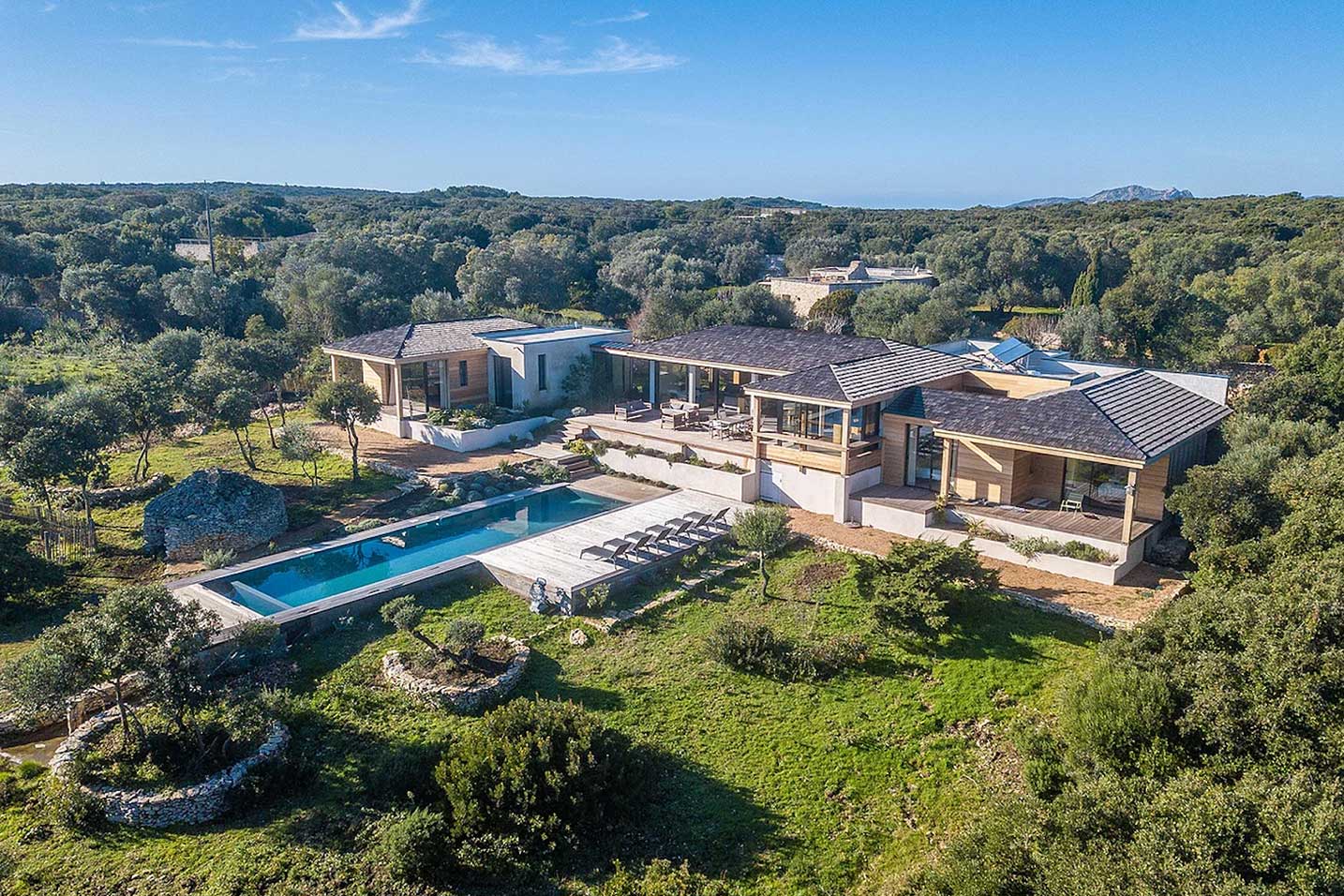 villa avec une piscine entourée d'une foret