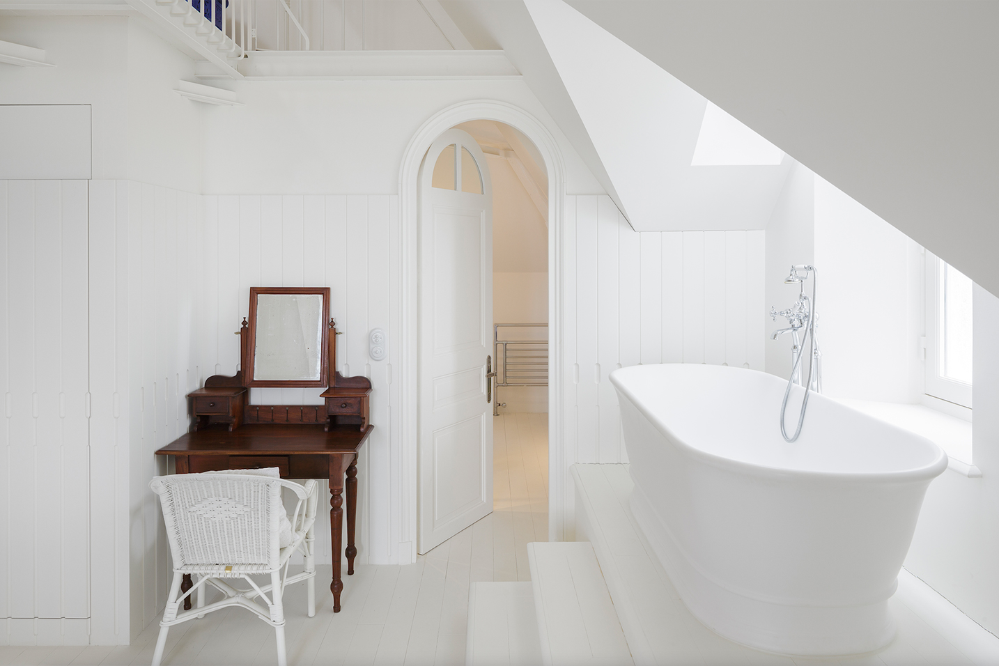 baignoire dans une salle de bain entièrement blanche