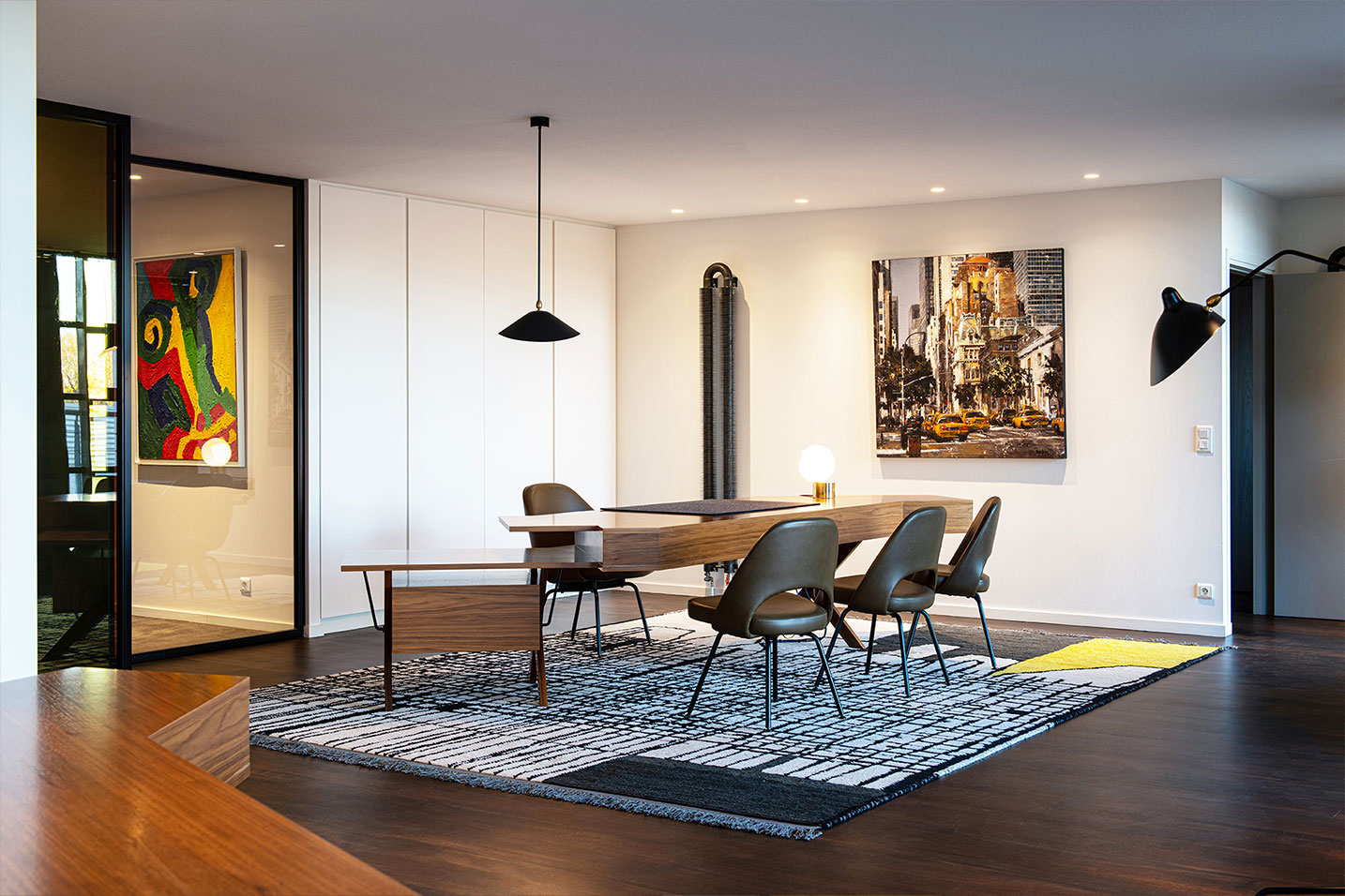 bureau géométrique en bois et chaises en cuir avec un tapis graphique coloré