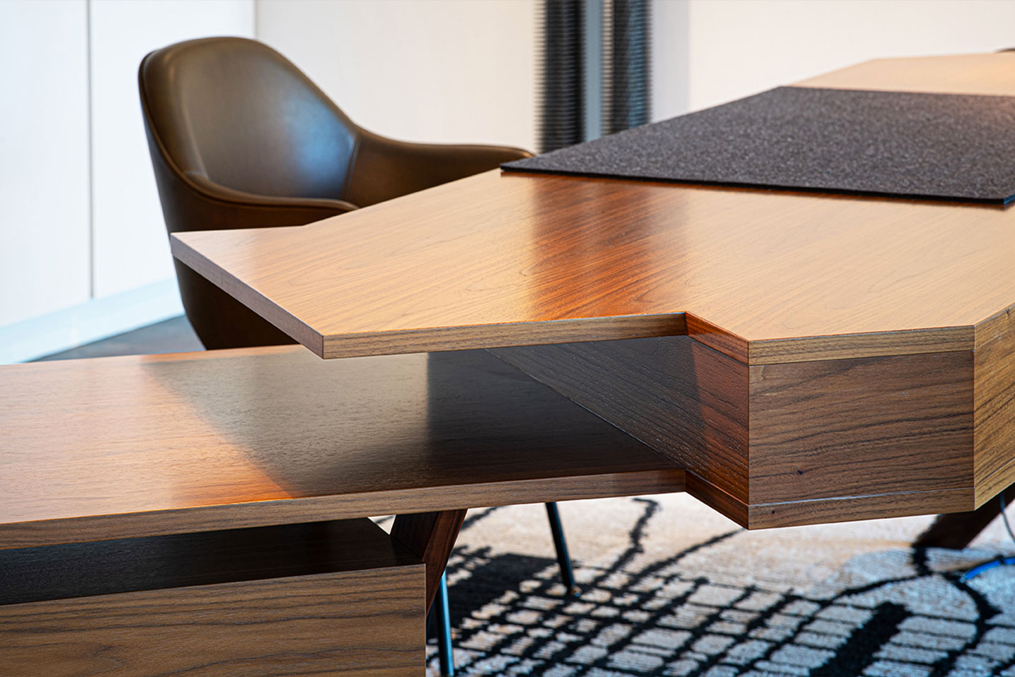 bureau géométrique en bois avec une chaise en cuir marron