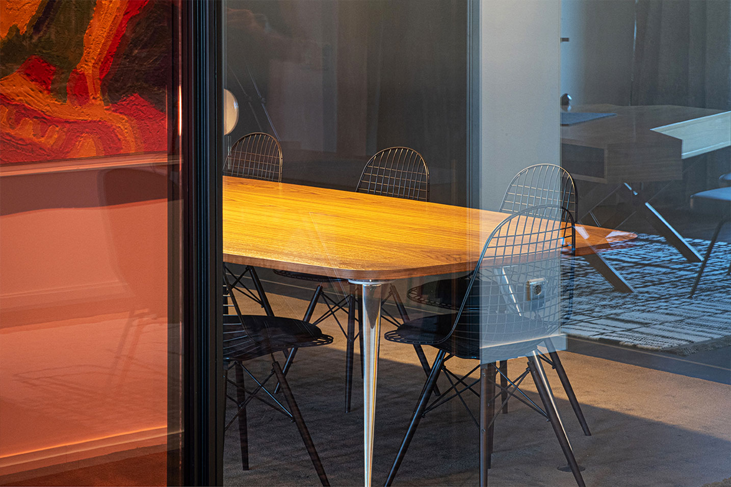 table en bois avec plusieurs chaises noires quadrillées